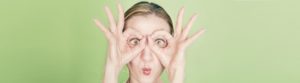 mujer haciendo anteojos con las manos que evoca al diagnóstico precoz del cáncer