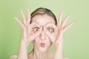 mujer haciendo anteojos con las manos que evoca al diagnóstico precoz del cáncer